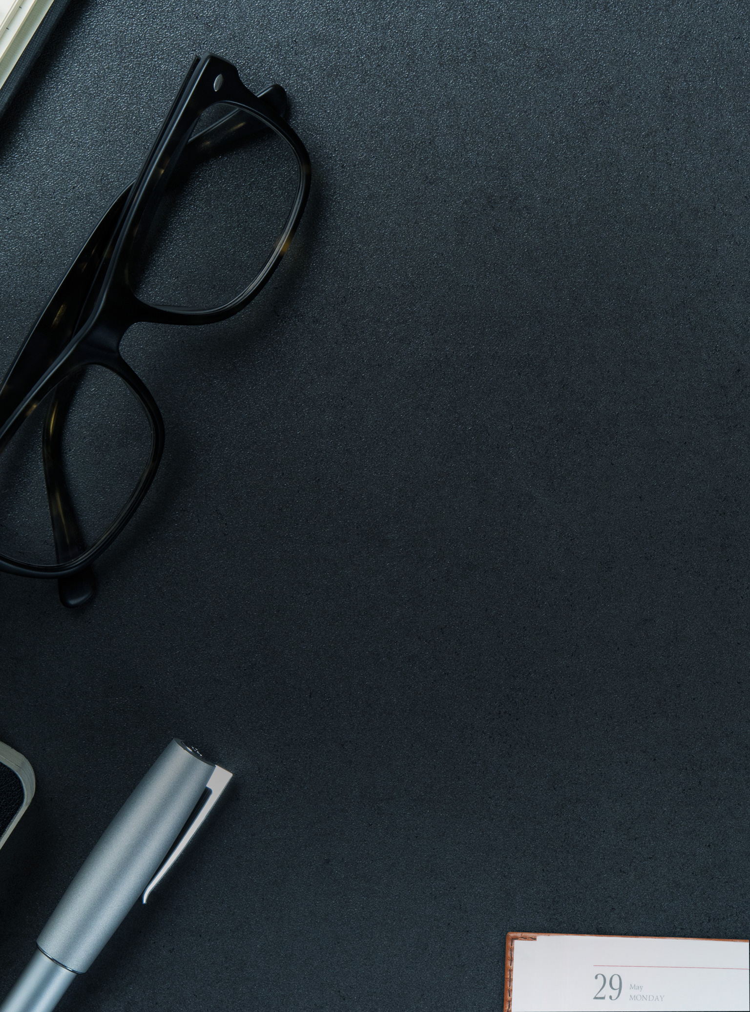 Close up of black glasses on desk.